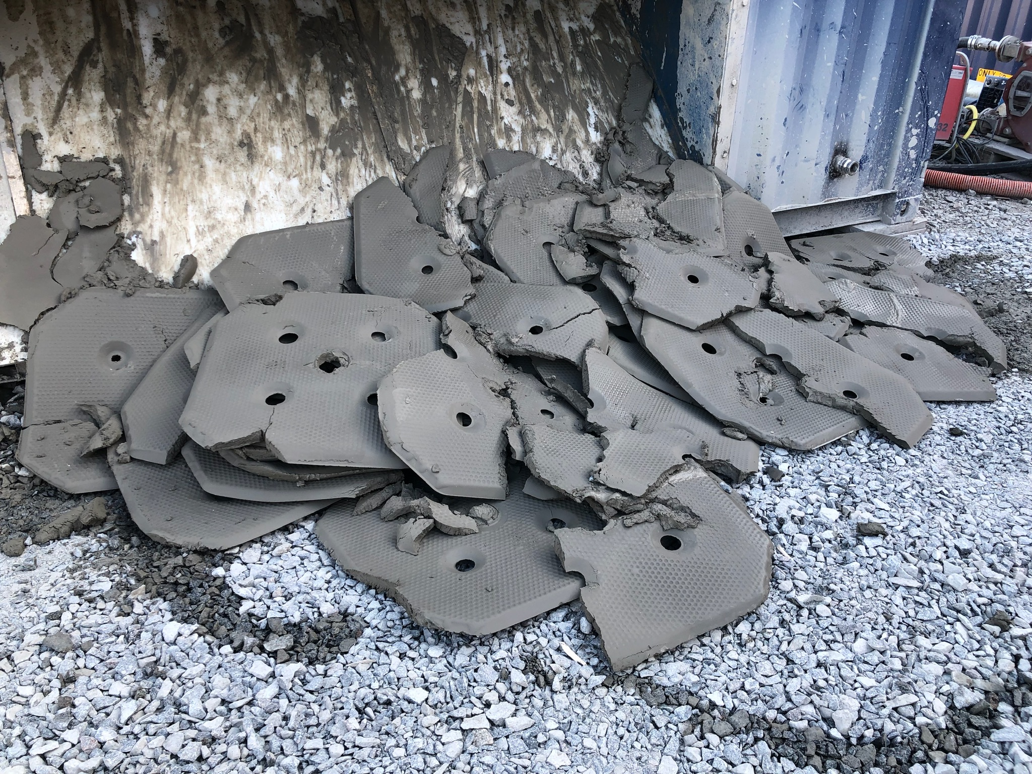 Grå filterkakor i en hög efter tömning av en filterpress